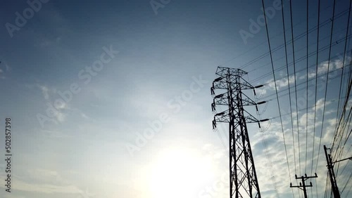 Time lapse of electric pylon tower High Voltage power line wires with clouds against blue sky, energetic global crisis power supply photo