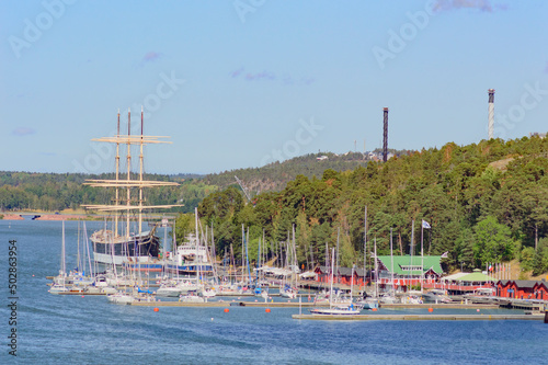 Windjammer bark Pommern and small sailboats in the harbor of Mariehamn, Aland islands, Finnland. Blue sea water and light blue sky