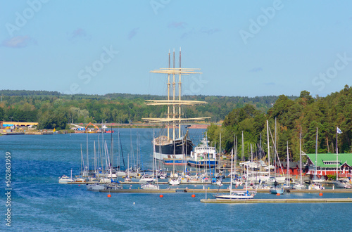 Windjammer bark Pommern and small sailboats in the harbor of Mariehamn, Aland islands, Finnland. Blue sea water and light blue sky