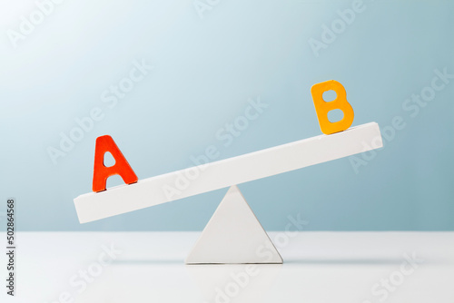 letter a and b on the unbalanced seesaw. evaluation concept. photo