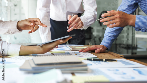 Team work discussing in valuation data in meeting room, three business people with accounting paper charts.
