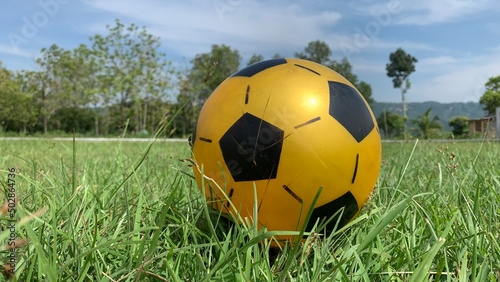soccer ball with yellow and black colors on grass 