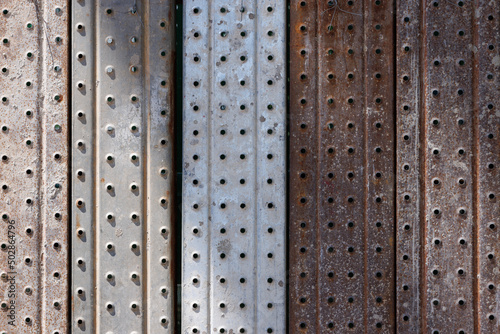 light and shadow on metal wall. steel with holes background and texture.