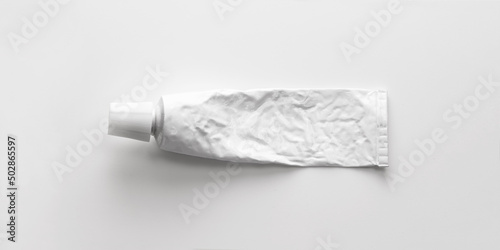 A blank white tube commonly used for pharmaceutical use or chemical products such as ointment, adhesives. With Lid on. Real life used condition. Isolated on natural white background.