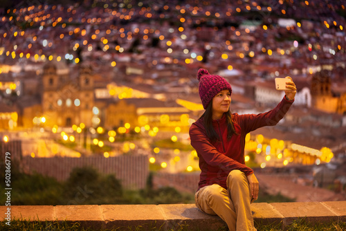 Turista sentada en el mirador tomándose un selfie hacia la plaza de Cuzco photo