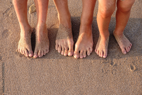 Three pairs of feet on the sand. Family on vacations. © Dmitrii Potashkin