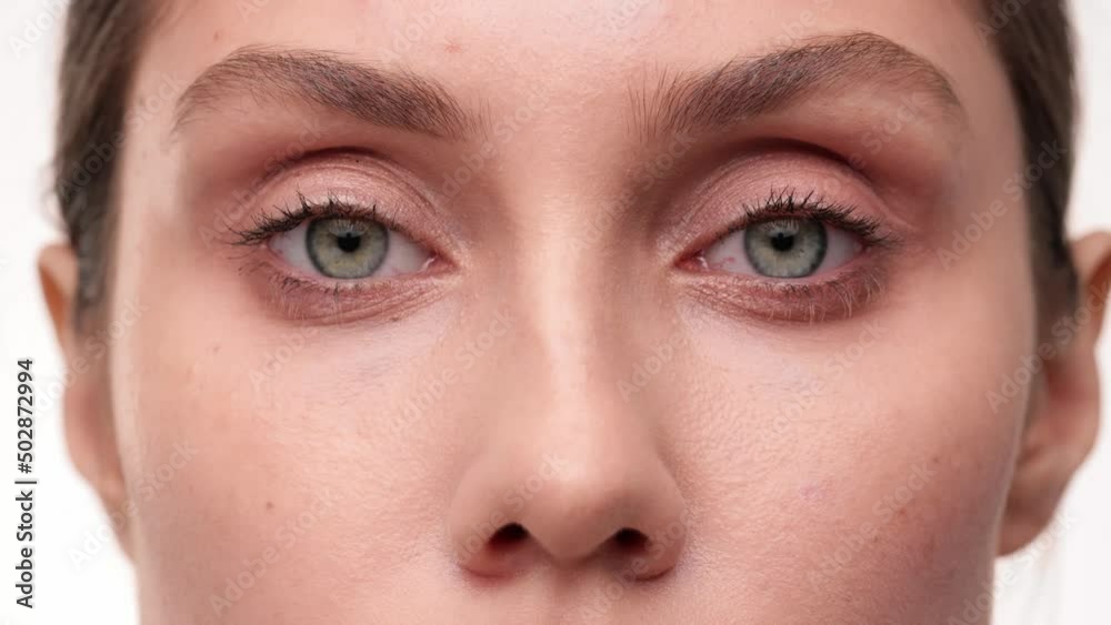 Close up. Macro zoom shot of eyes. Slow motion. Attractive brunette girl look at the windows. Caucasian beautiful female face. Young woman eyes opening while looking at Camera, having long Eyelashes.
