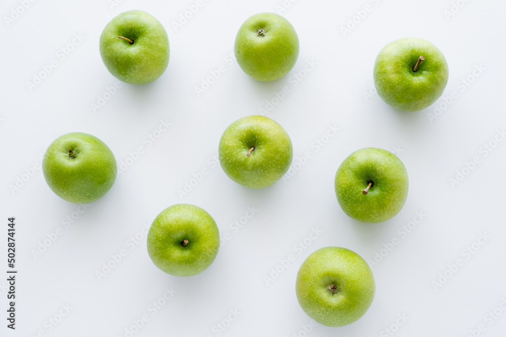 flat lay of green and ripe apples on white. - obrazy, fototapety, plakaty 