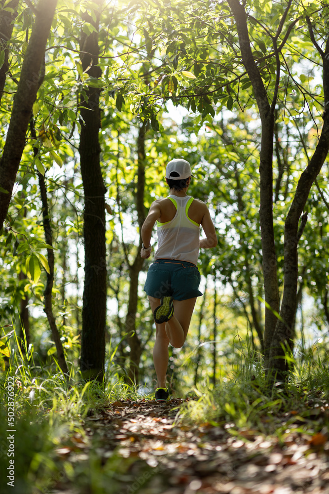 Woman runner running on forest trail Woman runner running on forest trail