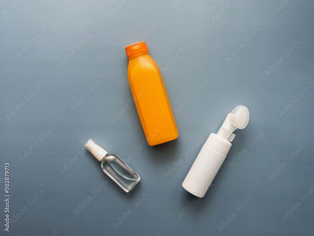 Top view of various plastic tubes: body lotion, facial wash, body oil. The concept of skin care after taking a shower. Blue background. Copy space. Place for text. Horizontally Top view of various plastic tubes: body lotion, facial wash, body oil. The concept of skin care after taking a shower. Blue background. Copy space. Place for text. Horizontally
