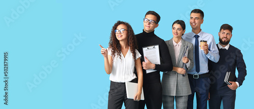 Team of young business people on blue background with space for text photo