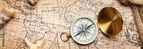Vintage compass with sea shells on world map. Travel concept