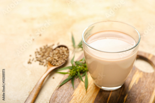 Glass of healthy hemp milk on light background, closeup
