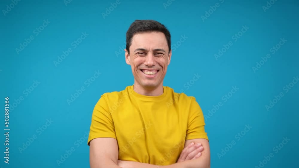 Cheerful man standing with crossed arms and laughing in studio Cheerful man standing with crossed arms and laughing in studio
