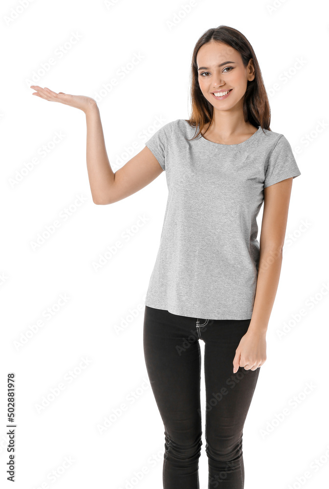 Pretty young woman in stylish t-shirt showing something on white background Pretty young woman in stylish t-shirt showing something on white background