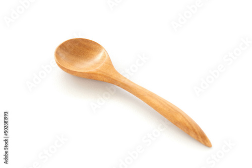 A wooden spoon is placed on a white ceramic background. Concept of isolated objects on a white background. Shot in natural light.