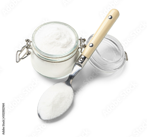 Jar of baking soda and spoon on white background photo