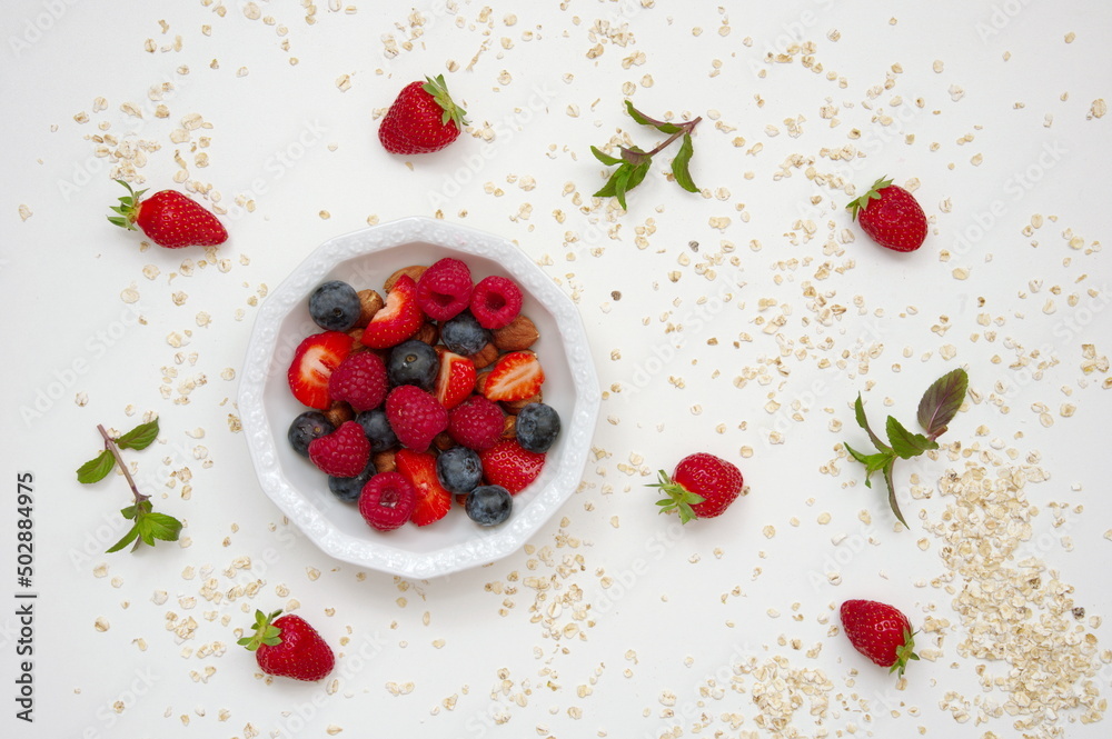 Flat lay of strawberries in white bowl against white background