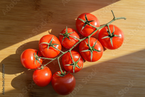 Natural-looking tomatoes on wooden background. Selective focus.