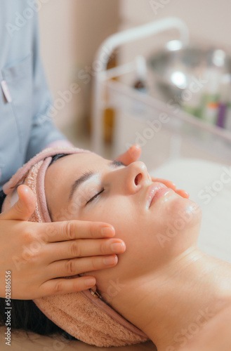 Young woman having fun during facial massage.