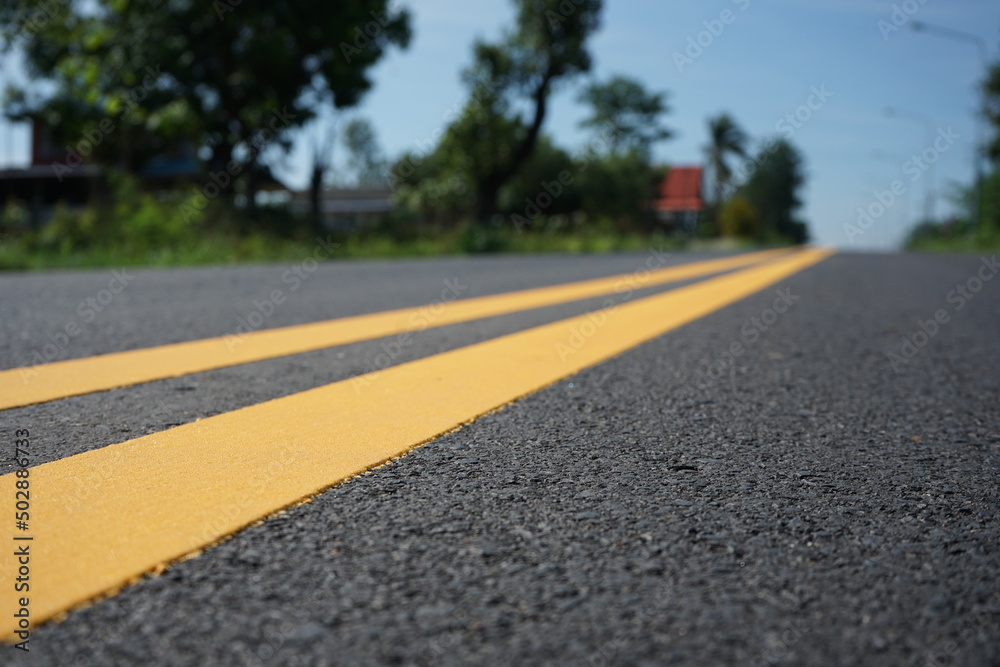 Blurred image, paved road and yellow traffic markings Blurred image, paved road and yellow traffic markings