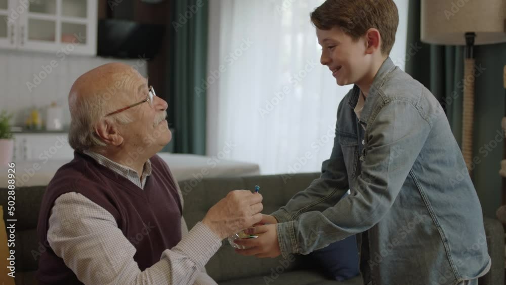 Offering Candy Boy offering candy in bowl to his old grandfather.Little boy offering ...