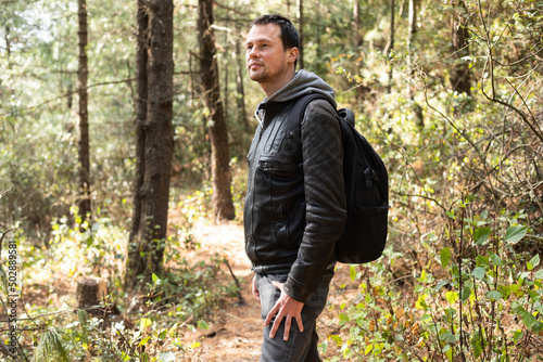 Young man on a walk in nature forest on sunny day