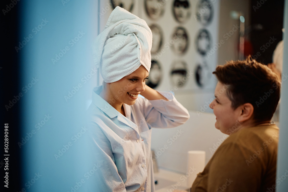 Fototapeta premium Young happy woman talks to her girlfriend in bathroom.