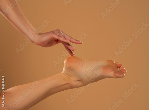 Perfect clean female feet . Beautiful and elegant groomed woman's hand touching her foot . Spa ,scrub and foot care