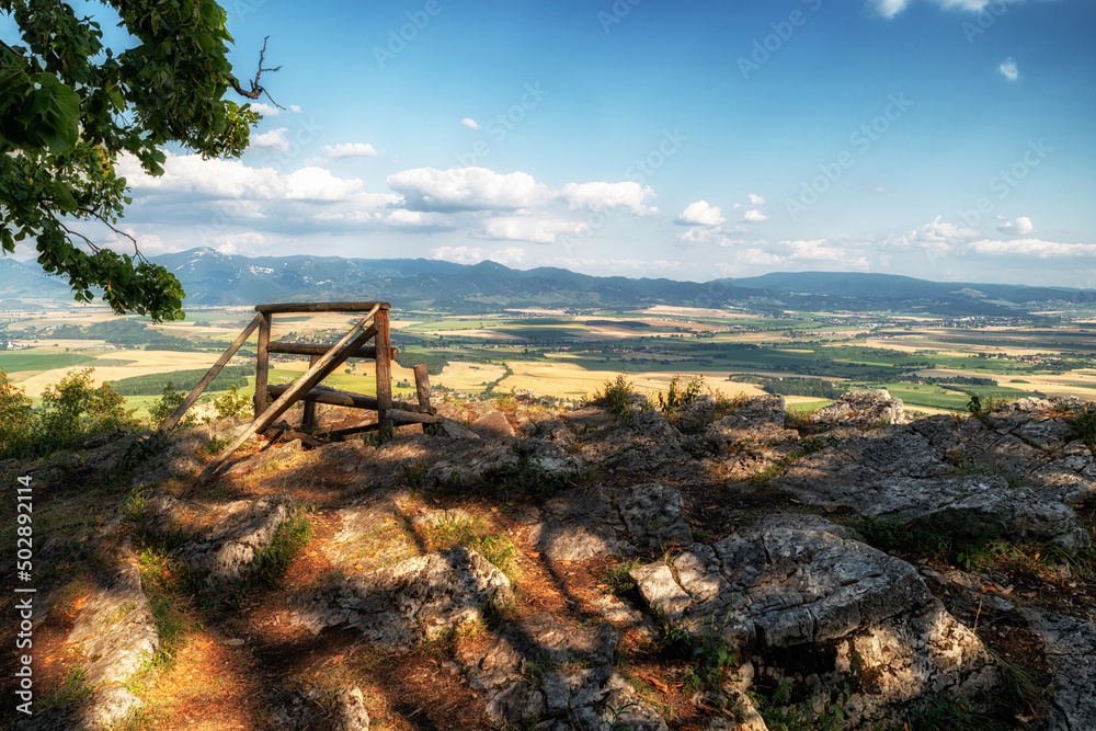 Lonely empty bench with beautiful view on summer countryside on hill called Ondrasovska skala, Slovakia Lonely empty bench with beautiful view on summer countryside on hill called Ondrasovska skala, Slovakia