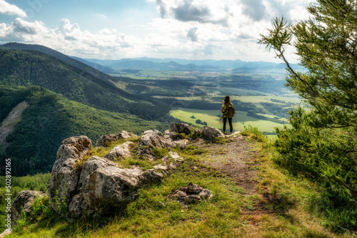 Hiking girl with backpack looking on beautiful summer mountain landscape from hill Cipcie in Slovakia