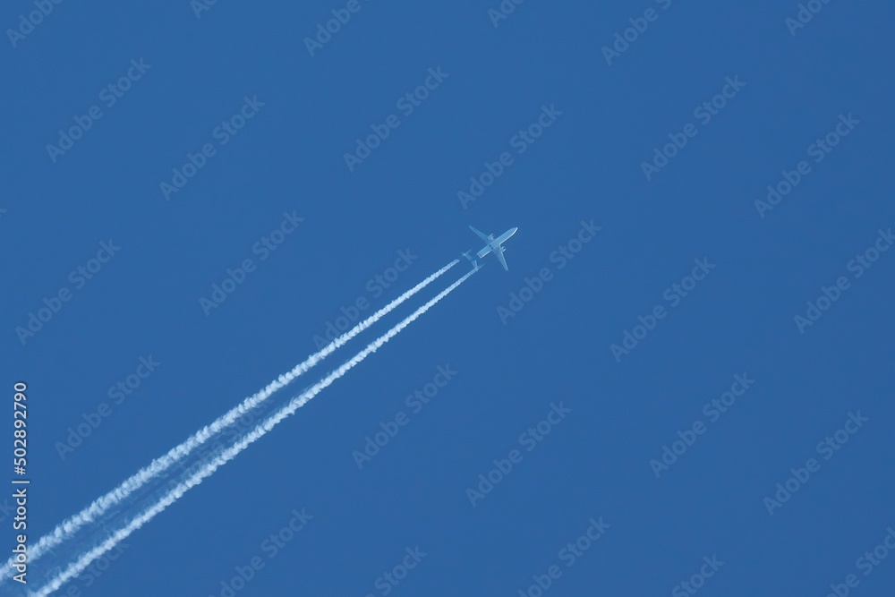 Passenger jet plane flying on high altitude on clear blue sky leaving white smoke trace of contrail behind. Passenger jet plane flying on high altitude on clear blue sky leaving white smoke trace of contrail behind.