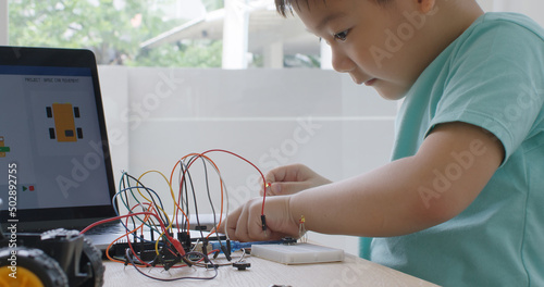 Wallpaper Mural Asia home school young small kid happy smile self study online lesson excited make AI circuit toy. STEM STEAM digital scratch class on laptop screen for active children play arduino enjoy fun hobby. Torontodigital.ca