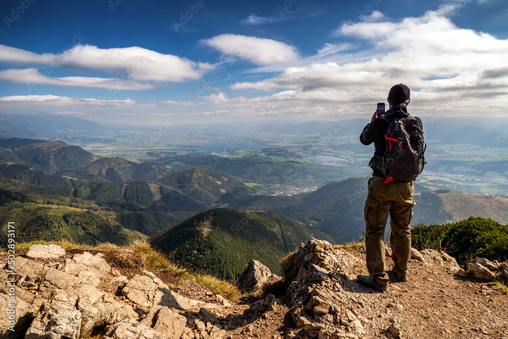 Hiker on top of the hill Velky Choc making photo of beautiful mountain landscape in Slovakia