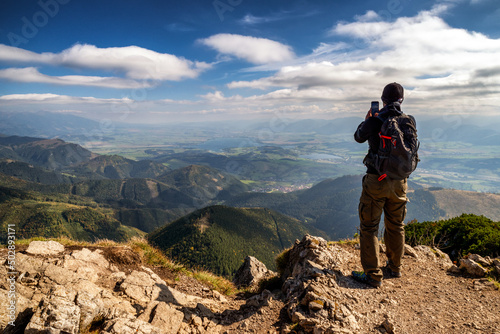 Hiker on top of the hill Velky Choc making photo of beautiful mountain landscape in Slovakia