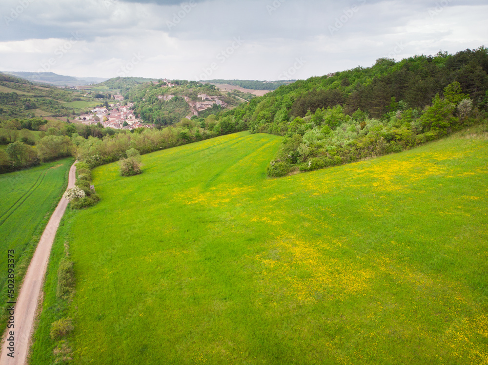Vue aérienne d'une route traversant des prés et des collines. Un paysage de campagne en Bourgogne. Le village de Saint-Romain. Vue aérienne d'un paysage agricole et de montagnes