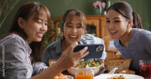 Asia teen girl vlogger group look camera VoIP talk on reel IG tiktok app filming shoot live share vlog. Gen Z youth people enjoy food dinner lunch at reopen cafe with fun joy party laugh relax smile.