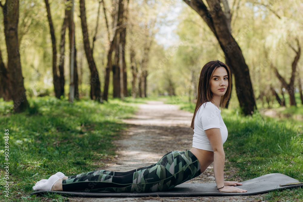 Young woman doing yoga in morning park