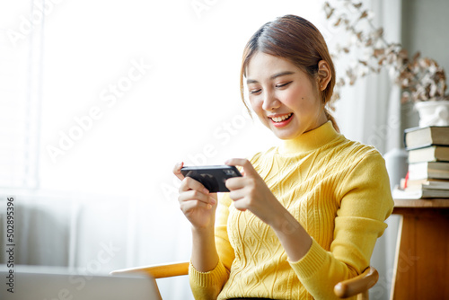 Asian young woman happiness and enjoy play game application from mobile phone connect internet with copy space