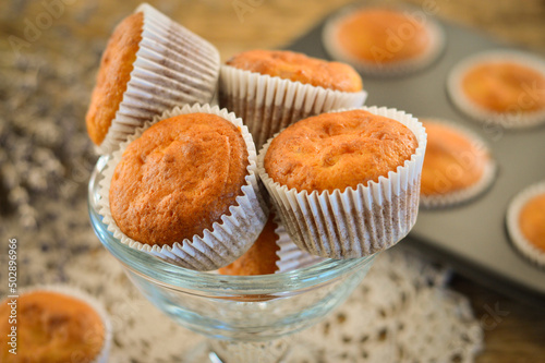 Homemade muffins. Muffins in baking molds. Muffins on a wooden background.