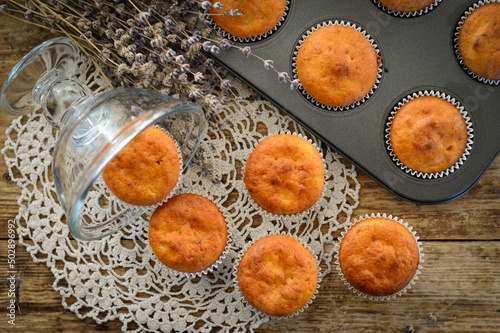 Homemade muffins. Muffins in baking molds. Muffins on a wooden background.