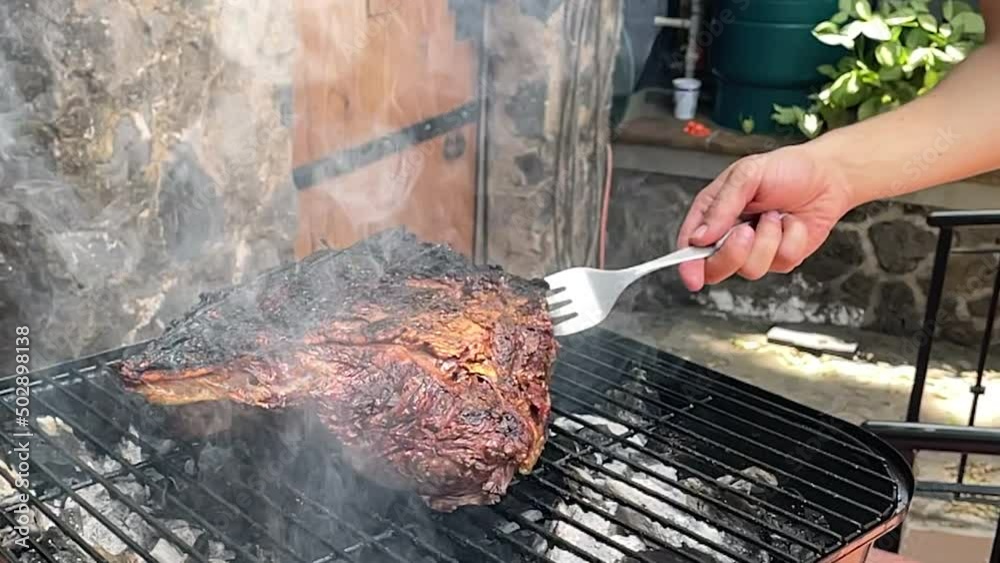 slow motion scene of meat being cut ready to be removed from the grill with a fork