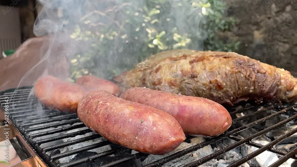 slow motion scene of meat cutting and raw sausages put on the grill