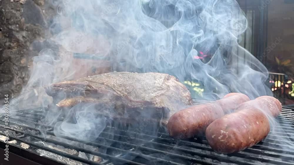 slow motion scene of juicy cut of Argentine meat on the grill and sausages