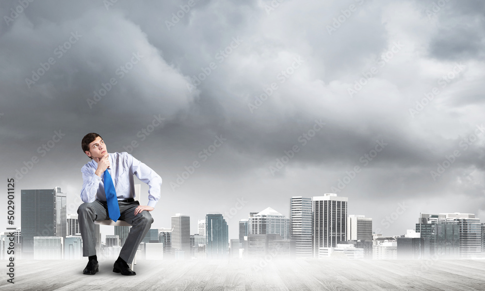 Young businessman sitting on an office chair Young businessman sitting on an office chair