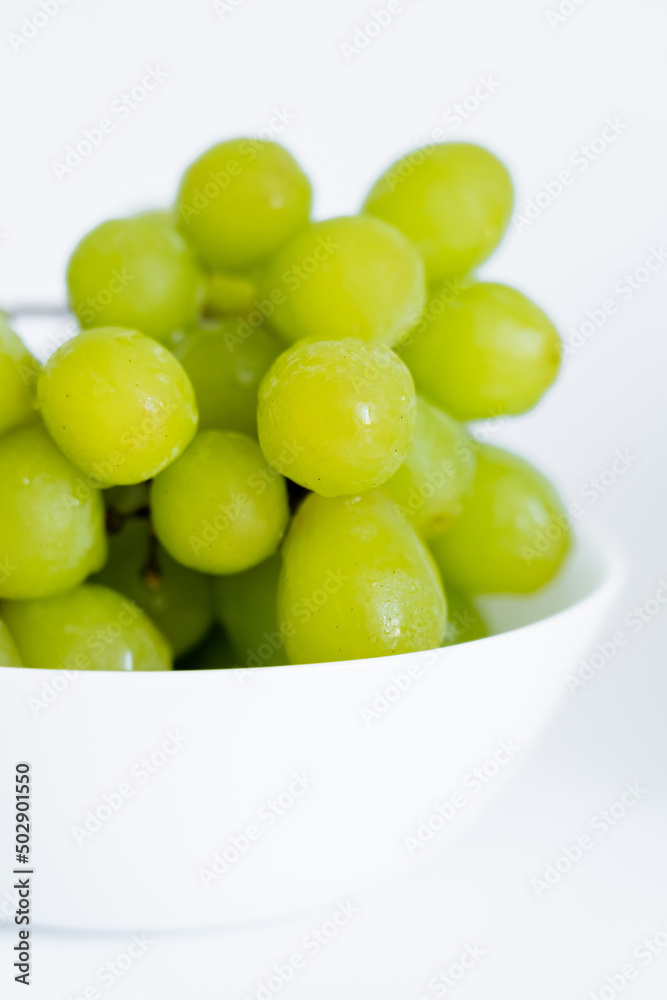 close up view of sweet green grapes in bowl on white. close up view of sweet green grapes in bowl on white.