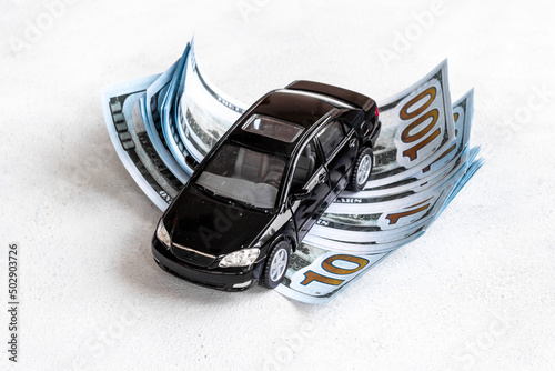 Money to buy or rent a car concept. Toy car with money cash