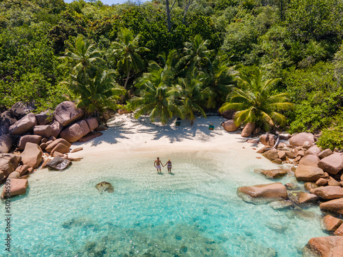 Praslin Seychelles tropical island with withe beaches and palm trees, couple of men and women mid age on vacation at Seychelles visiting the tropical beach Anse Lazio Praslin Seychelles. drone view  photo