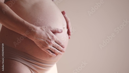 pregnant woman. health pregnancy motherhood procreation concept. close-up belly of sunlight a pregnant woman. woman waiting for a newborn baby. pregnant woman holding her belly indoors