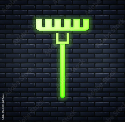 Glowing neon Garden rake icon isolated on brick wall background. Tool for horticulture, agriculture, farming. Ground cultivator. Housekeeping equipment. Vector